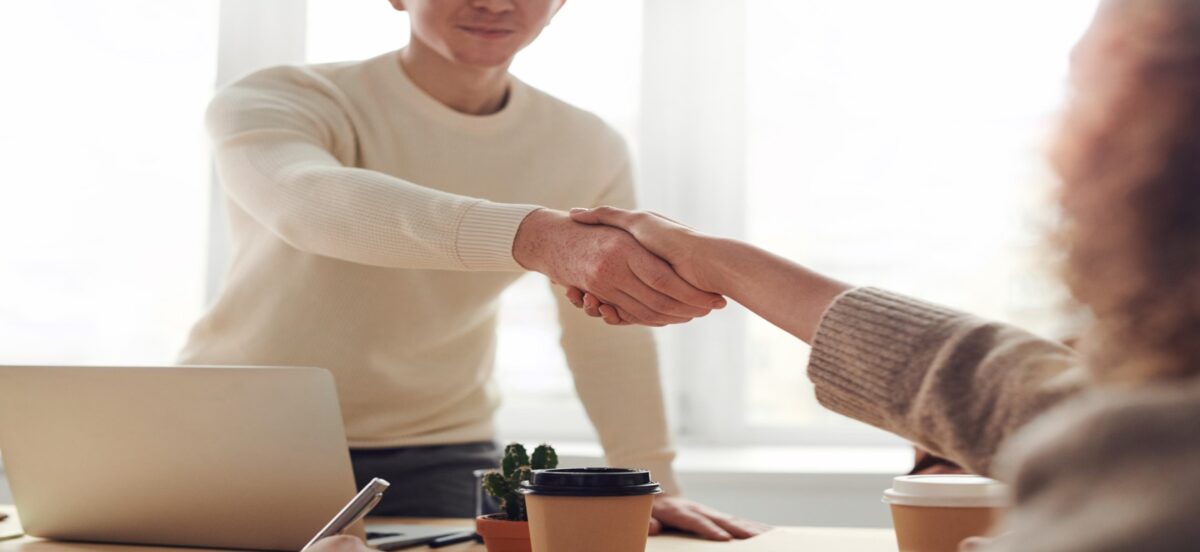 In this office, a man and woman are engaged in a handshake, symbolizing a successful partnership.