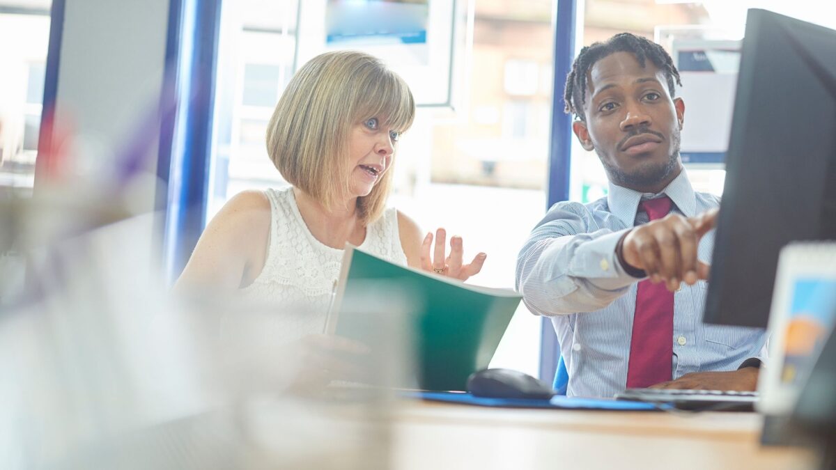 Two people engaging in a short course that focuses on key skills to use at home and in the workplace, while looking at a computer screen.