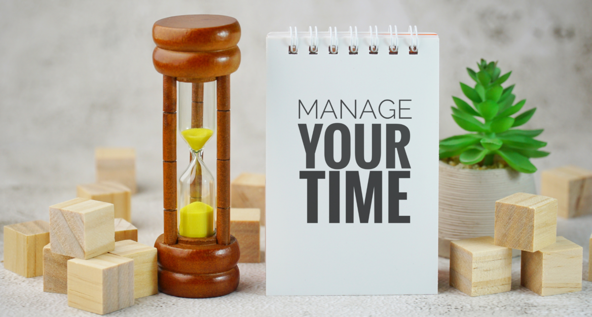 A notebook with the words time management techniques next to a wooden block.