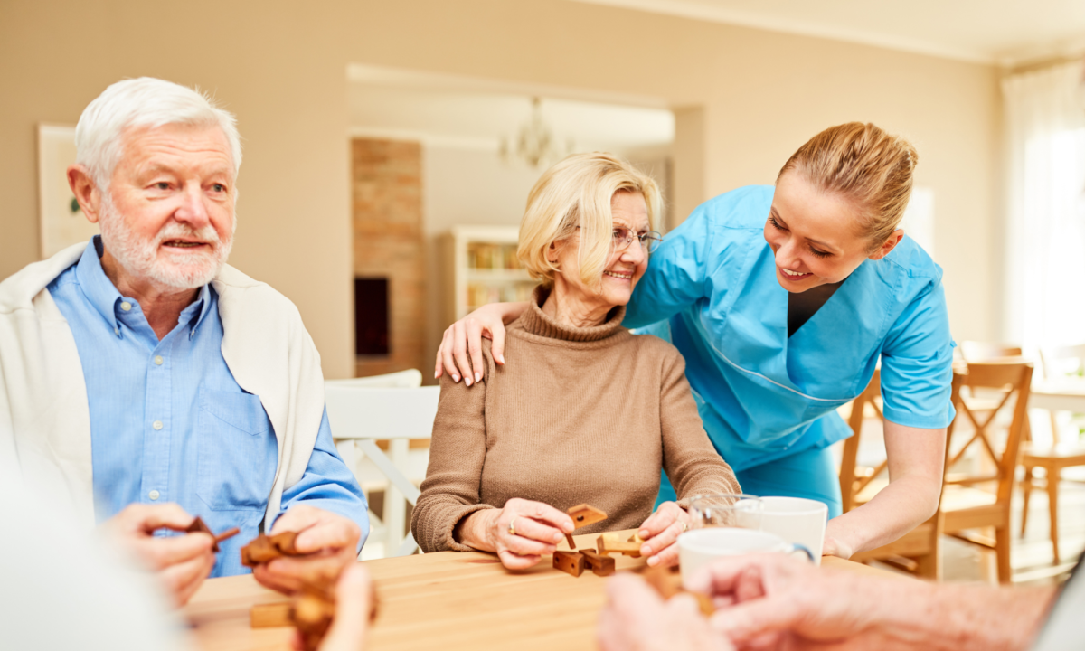 A female care worker attending to people with dementia in a care setting
